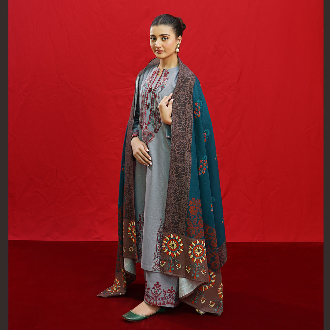 Woman wearing a grey Urgu embroidered Dhanak suit with a teal and brown printed shawl