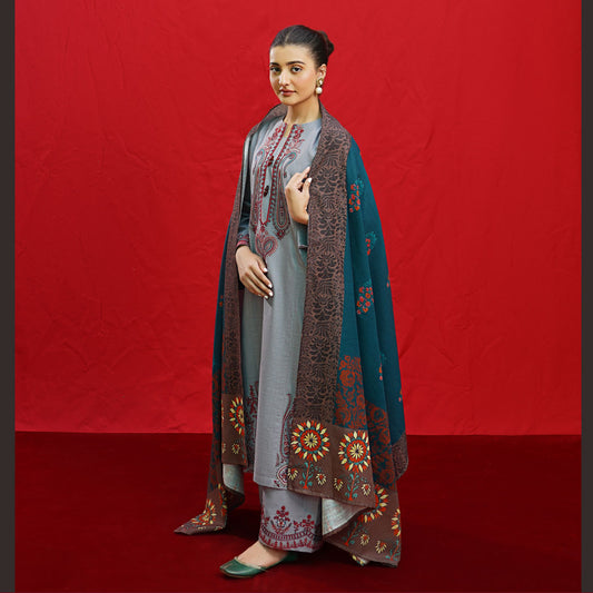 Woman wearing a grey Urgu embroidered Dhanak suit with a teal and brown printed shawl